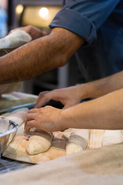 Baker making beguette before putting it in the oven.