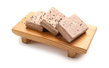 Wooden board with pieces of tasty sesame halva on white background