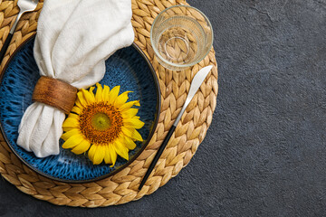 Stylish table setting with sunflower on dark background