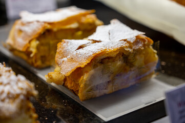 Austrian desserts, piece of apple strudel on display in traditional bakery cafe in Vienna.