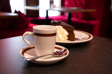 Small cup of black espresso coffee served in traditional cafe in Vienna with red interieur, Austria