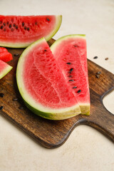 Cutting board with slices of watermelon on white background, closeup