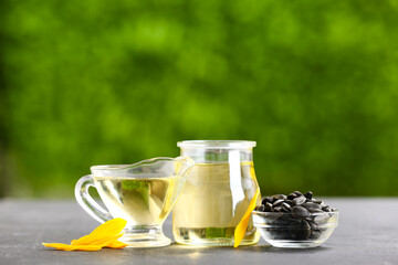Bottle and gravy boat of sunflower oil on table outdoors