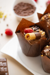 cupcake with crispy waffles,chocolate decor on a beige background.Chocolate dessert.Chocolate cupcake.Appetizing muffin set.Assorted sweet table.Baked goods and desserts 