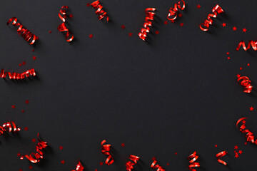 Frame of red party streamers and confetti on black background. Black Friday sale banner design....