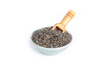 Puy or French Green Lentils in a Green Pottery Bowl with a Wooden Scoop Isolated on White