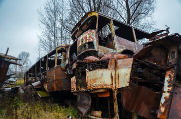 Broken destroyed rusty buses in recycling scrap yard
