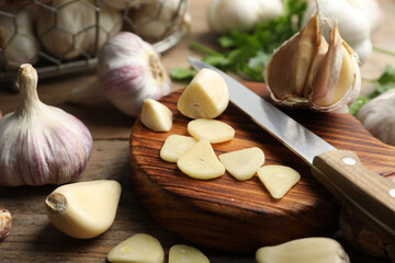 Fresh sliced and whole garlic on wooden table, closeup. Organic product