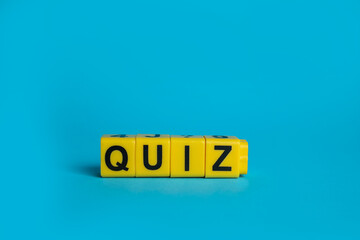 Yellow cubes with word Quiz on light blue background. Space for text