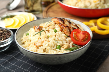 Delicious chicken risotto with tomato on table, closeup