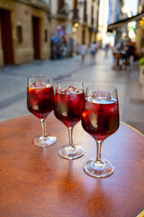 Glasses of cold sangria wine served outdoor in bar with view on old street in San Sebastian, Basque Country, Spain