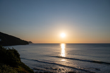 Sunset in calm waters of Atlantic ocean and clear sky