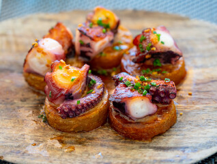 Spanish starter in fish restaurant in Getaria, grilled octopus with roasted potatoes and paprika, Basque Country, Spain © barmalini