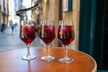 Glasses of cold sangria wine served outdoor in bar with view on old street in San Sebastian, Basque Country, Spain
