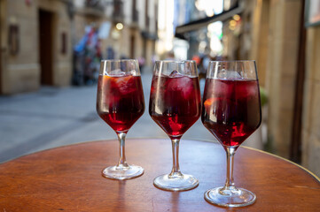 Glasses of cold sangria wine served outdoor in bar with view on old street in San Sebastian, Basque Country, Spain