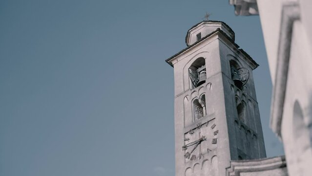 Reveal of the Chiesa Arcipretale di Sant'Eufemia e Battistero clock bell tower in Ossuccio italy at famous Villa Balbiano lake como