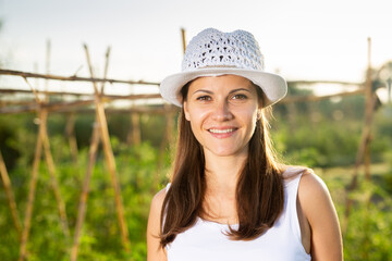 Portrait of young adult female amateur gardener standing in homestead
