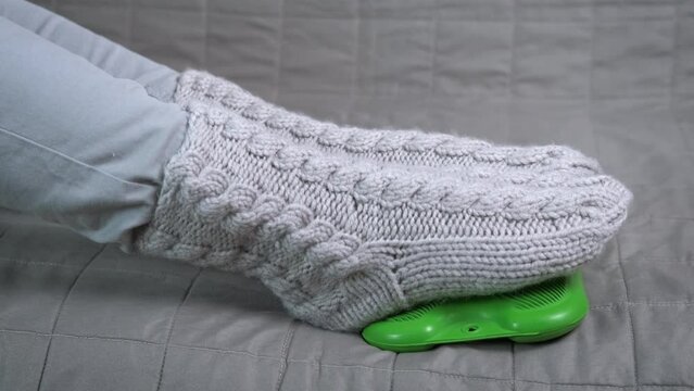 Legs on heating pad. A view of child legs in woolen socks on green heated pad try to keep warm in cold room during winter season.