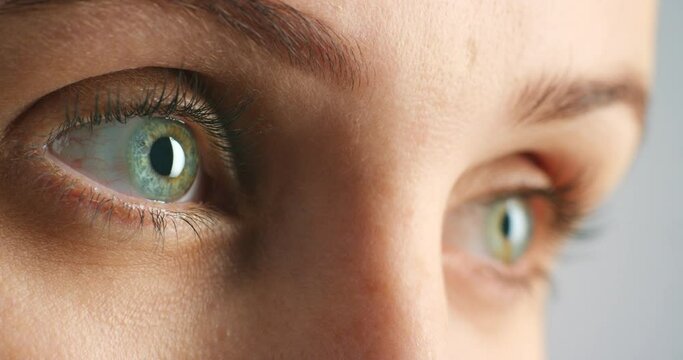 Woman blue eye with an intense looking blink while staring focused and thinking of ideas. Zoom in of face and eyes of a serious female with good vision or eyesight feeling awake with reflection