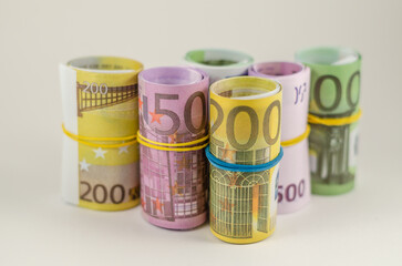 Euro banknotes in rolls are on the table.
