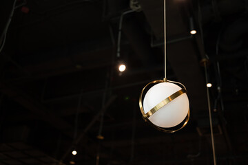 warm lights hanging from ceiling in local restaurant. Close-up shot with blurred background. Negative copy space