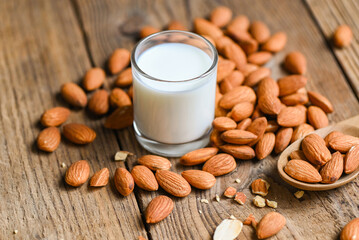 Almond milk and Almonds nuts wooden background, Delicious sweet almonds on table, roasted almond...