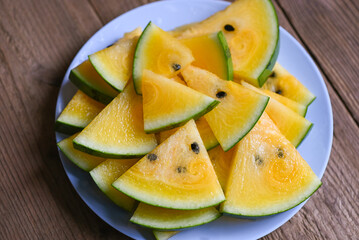 Sweet watermelon slices pieces fresh watermelon tropical summer fruit, Yellow watermelon slice on plate and wooden background