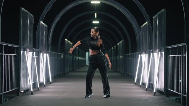 female hip-hop dancer is moving in dark tunnel of metro crossing, flashmob and challenge