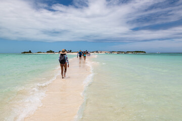 Cayo de Agua (Los Roques Archipelago), Venezuela, 07.30.2022: tourists walking on a sandbank...
