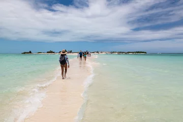 Foto op Canvas Cayo de Agua (Los Roques Archipelago), Venezuela, 07.30.2022: tourists walking on a sandbank between two small islands in the caribbean sea. © Giongi63