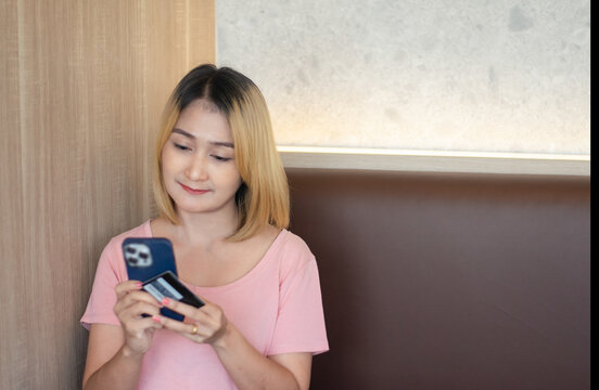 woman holding mobile phones online to purchase shopping using credit cards to pay order code discounts by payment website at home