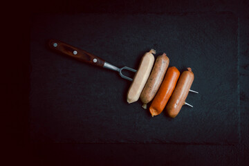 Raw barbecue sausages on a slate plate