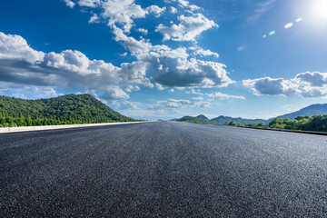 Straight asphalt road and green mountain nature background
