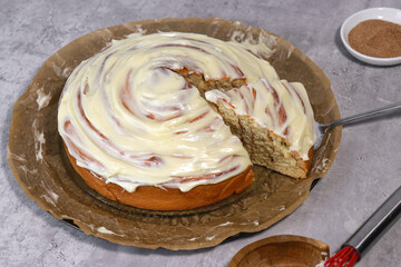 giant cinnamon roll with buttercream frosting,, grey marble table