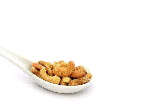 Cashew nuts on a white ceramic spoon