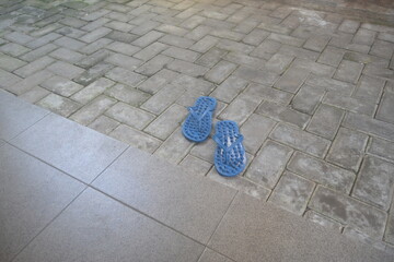 blue sandals on the gray paving yard