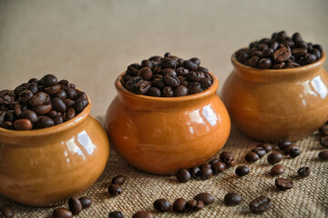 Clay pots filled with fresh roasted coffee beans, close-up. Assortment of coffee varieties for connoisseurs of refreshing drink.
