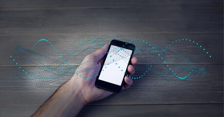 Composition of dna strand over person using smartphone with blank screen