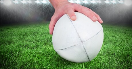 Composition of male rugby player holding rugby ball over sports stadium