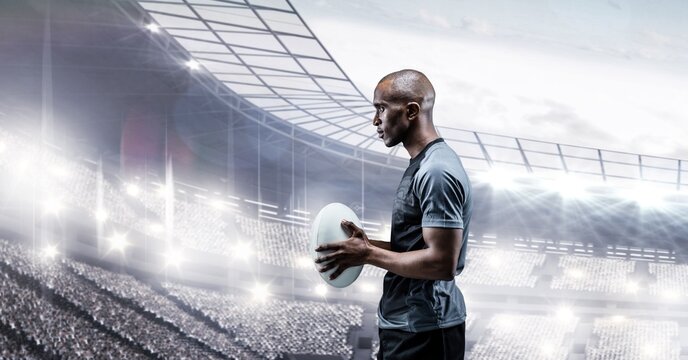 Composition of male rugby player holding rugby ball over sports stadium