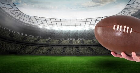 Composition of male rugby player holding rugby ball over sports stadium
