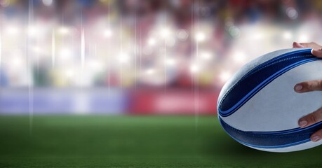 Composition of male rugby player holding rugby ball over sports stadium