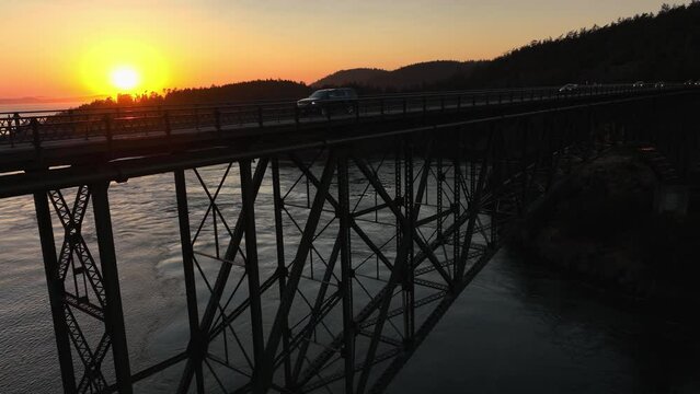 Slowly rising aerial shot of Deception Pass Bridge at dusk.