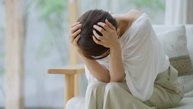 60p　リビングで落ち込むミドル女性