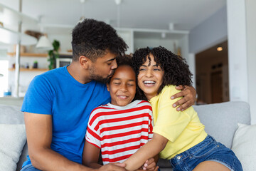 Family sitting on sofa smiling at camera on modern apartment background Happy family with daughter playing at home and weekend for family