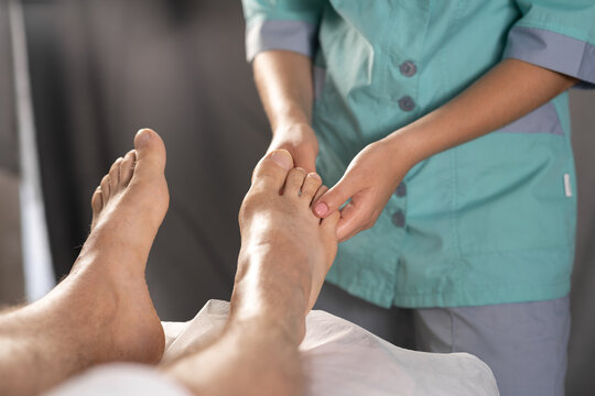 Man having foot massage in medical office. Close up photo of a spa professional having a feet massage session at salon