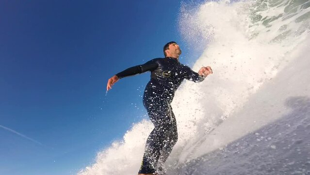 Close up slow motion shot of Handsome guy surfing a green wave in Praia da Arda surf spot. strong cutback on the end. generating a lot of speed. Afife, Viana do Castelo.