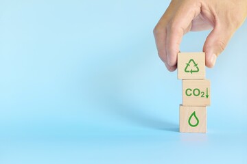 Recycling, sustainable and environment friendly business, CSR and ESG concept. Hand stacking wooden blocks with environmental conservation icons.