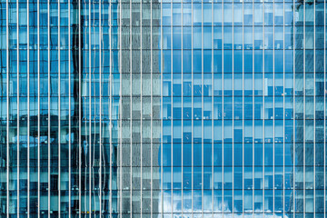 Fragment of a modern office building. Abstract geometric background. Part of a skyscraper with glass windows.