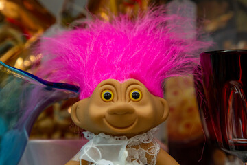 A toy doll with hot pink hair